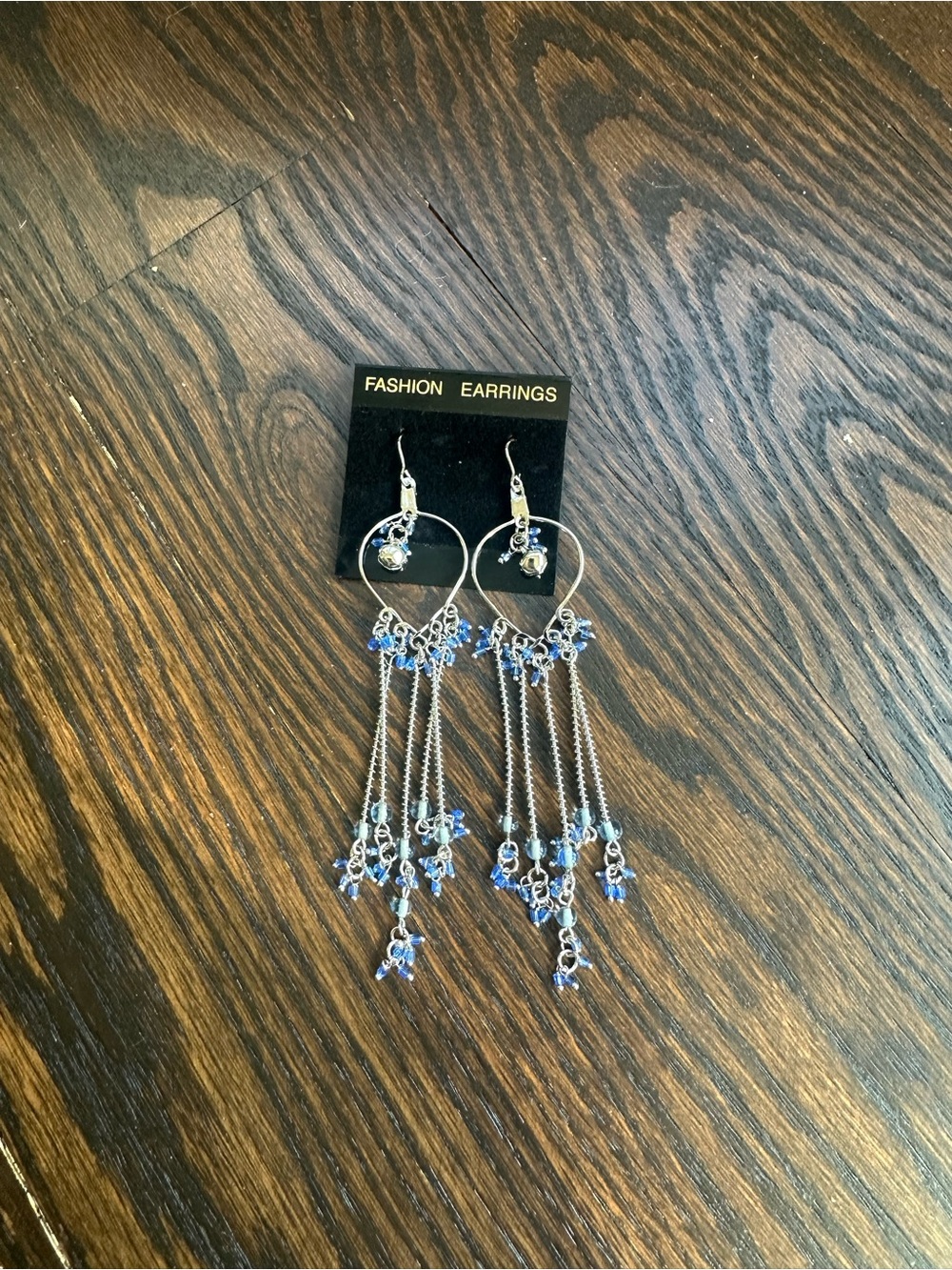 Silver-tone metal chandelier earrings with blue beads.